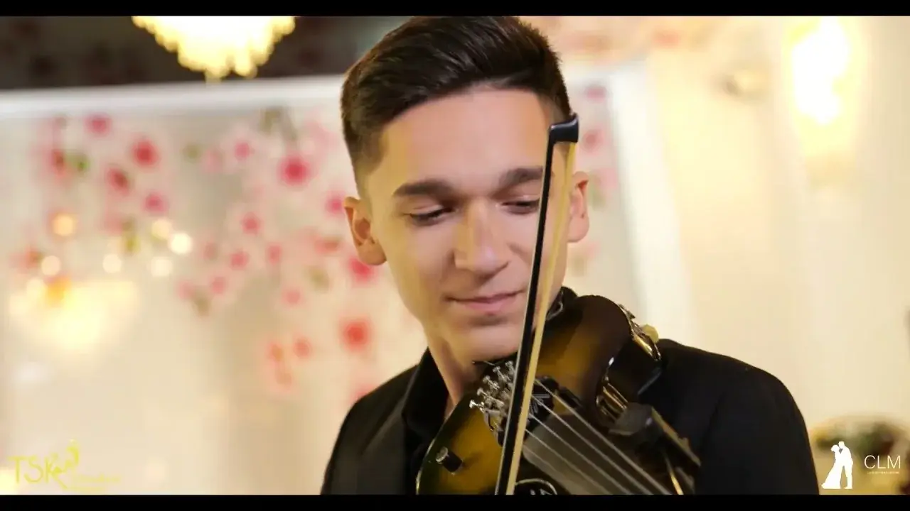 Violonistul cântând într-o sală decorată pentru nuntă